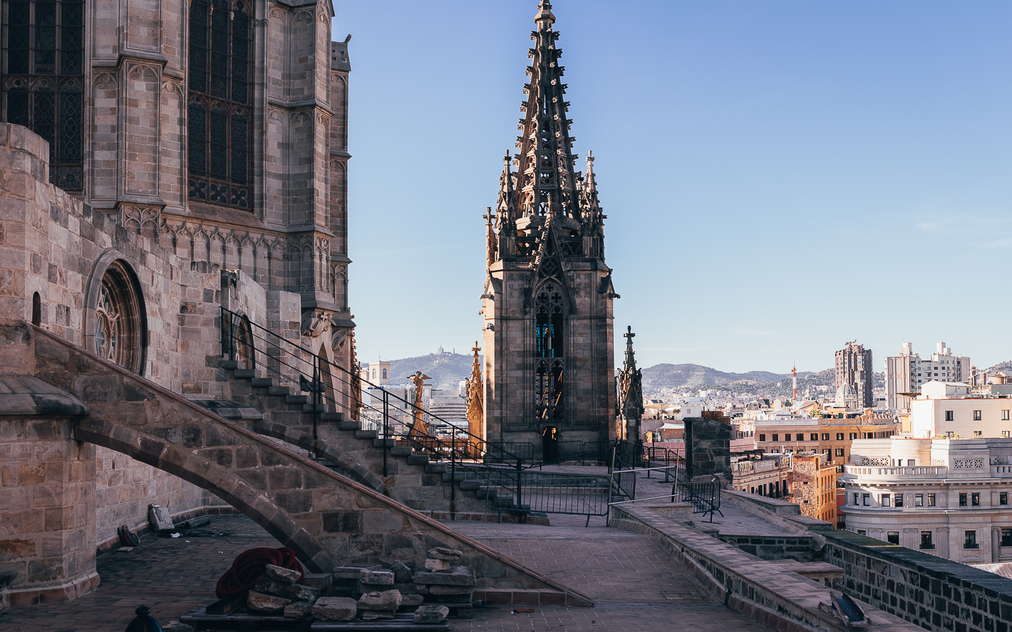 Dachterrasse der Kathedrale von Barcelona mit gotischem Turm und Blick über die Stadt bei klarem Himmel.