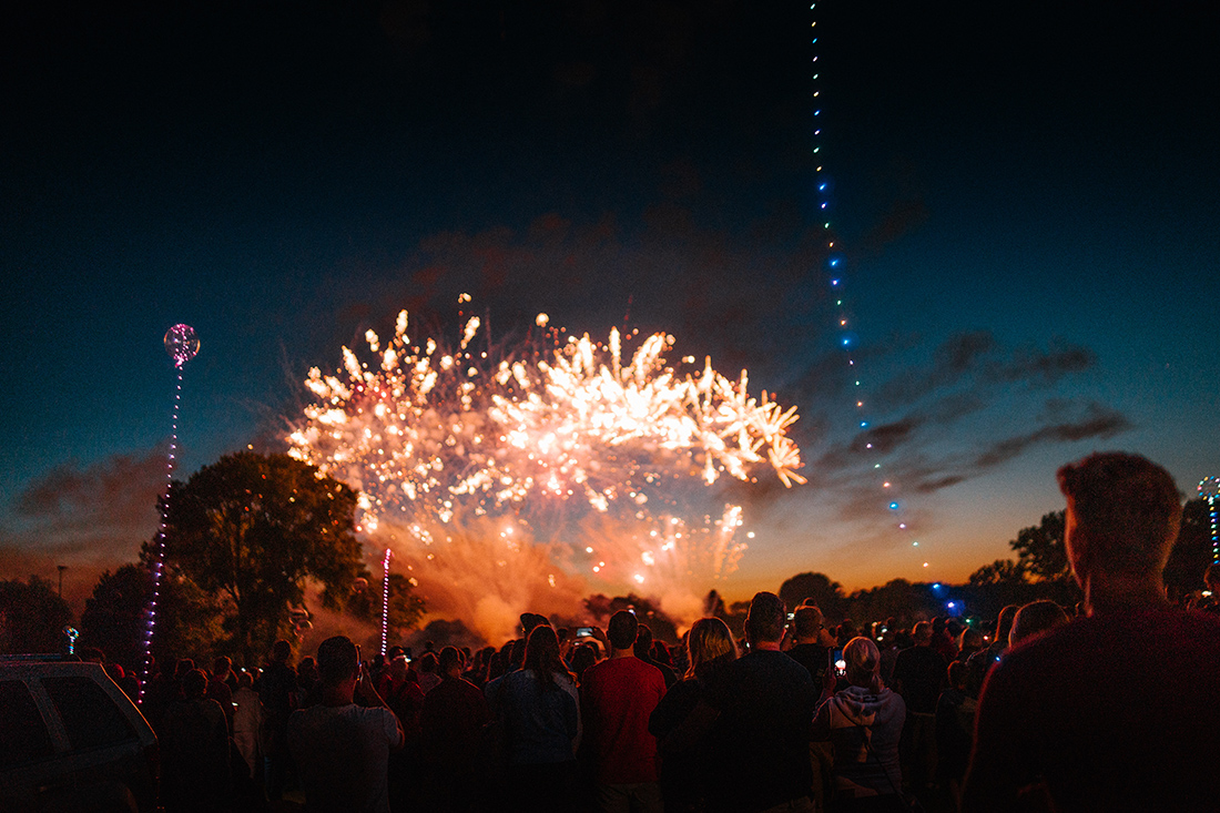 Menschenmenge bei Nacht beobachtet ein großes Feuerwerk am Himmel während der Kieler Woche in Kiel.